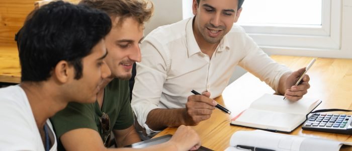 young-teacher-telling-two-students-about-corporate-budgeting (1)